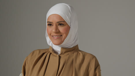 Retrato-De-Estudio-De-Una-Mujer-Musulmana-Sonriente-Usando-Hijab-Contra-Un-Fondo-Liso